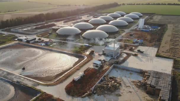 Biogasinstallatie midden in de natuur. Moderne opslagtanks op biogasboerderij op het veld. Duurzame energie uit biomassa. Luchtfoto 's. Energiebron. — Stockvideo