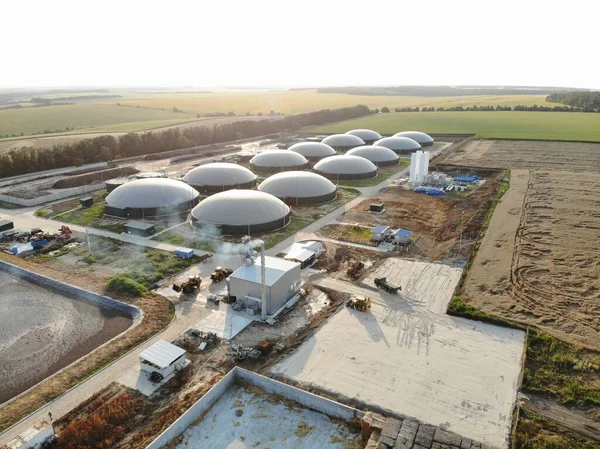 Bio gas factory. Biogas complex on nature landscape. Agricultural plant for biomass production on green field. Modern storage for renewable energy.