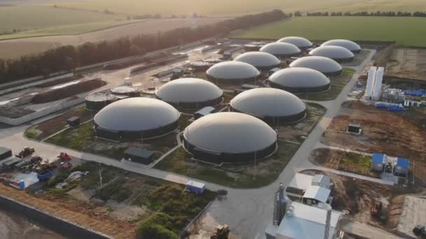 Biogáz farm a zöld mezőkön. Megújuló energia biomasszából. Modern mezőgazdasági biogáz üzem között gyönyörű környezetben. Légi felvétel. — Stock videók