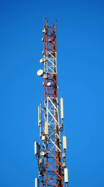 Telekomünikasyon GSM (5G, 4G, 3G) kulesinin tepesindeki teknoloji. Telekomünikasyon direği televizyon antenlerinin çatı katındaki cep telefonu antenleri. n