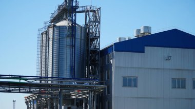 Tarımsal Silo - tahıl depolama ve kurutma için bina. Endüstriyel konsept, mavi gökyüzü üzerindeki silo kulesi