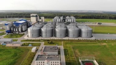 Asansörün metal tankları. Açık havada tahıl kurutma tesisi. Ticari ambarlar. Tarım ürünleri için çelik depo. Hava görünümü.