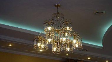 Tavanda lüks kristal avize. Alt manzara. Yakın plan. Mumları olan büyük kristal altın bir avize. n