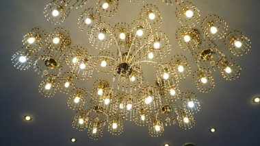 Tavanda lüks kristal avize. Alt manzara. Yakın plan. Mumları olan büyük kristal altın bir avize. n