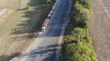 Tahıl teslimi. Tahıl deposu. Tahıl kamyonları tahıl ambarına giden yolda ayakta duruyor. Trafikte kamyonlar. Hasat ve ürün teslimatı. Tarım endüstrisi. Tarım.