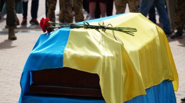 Cenaze vazosunda küller ve cenazede çiçekler. Çiçeklerle süslenmiş bir vazo ve cenaze töreninde yas tutan insanlar. Üzücü ve kederli bir şekilde ölen kişiye veda ediyorlar. n