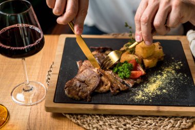 Patatesli biftek yiyen adamın kısmi görüntüsü