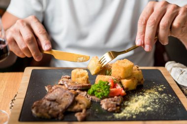 Erkeğin leziz et yemeklerini yediği yakın plan.