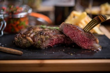 Siyah taş tahtada dilimlenmiş bifteğin yakın çekimi.