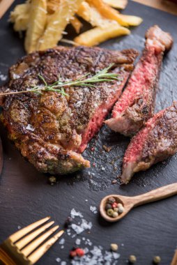 Parmesanlı ve biberiyeli patates kızartmasıyla servis edilen lezzetli biftek.