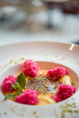 Kremalı lezzetli tatlı, doğranmış böğürtlen ve nane yapraklı.