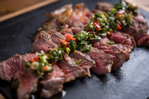 Kesilmiş bitkilerle kaplı harika dilimlenmiş sulu biftek.