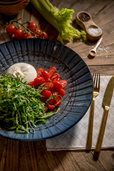 Pomodori Ciliegini Tagliati Rucola Mozzarella Serviti Piatto Nero — Foto Stock