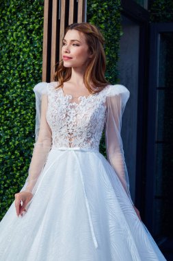 Güzel, güzel, esmer bir kadın güzel bir gelin büyük bir düğün günü yaz bahçesinde uzun ipek ve dantelli beyaz bir elbise içinde parlak bir saç stili saf bir aşk iç mekanı..