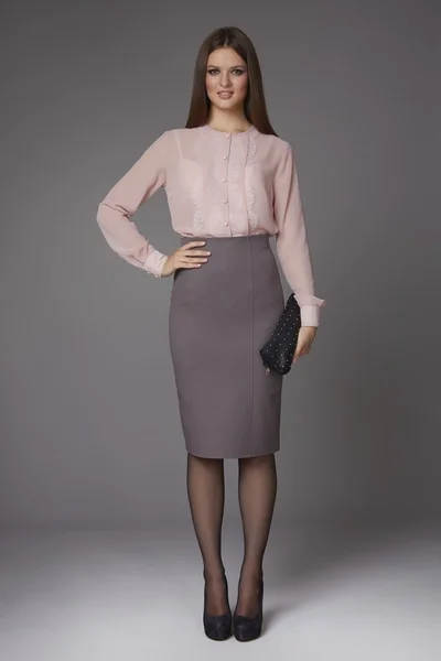 güzel seksi genç iş kadını akşam makyajlı diz ve dantel uzun kollu ve yüksek topuklu ayakkabılar, toplantılar ve yürüyüşler için iş giysileri ile bir ipek bluz etek giyiyor