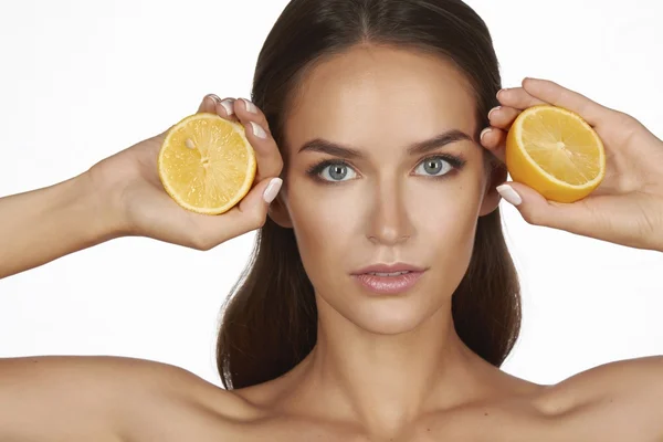 Vacker sexig ung kvinna med perfekt frisk hud och långa bruna hår dag makeup bara axlar håller orange citron grapefrukt sunda matvanor ekologiska livsmedel diet viktminskning — Stockfoto