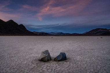Yarış pistinde iki yelken taşı yan yana dinlenirken ışık geceye karışıyor.