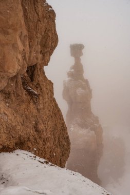 Bryce Kanyonu kar fırtınası sırasında arkasında çekiç olan uçurum duvarı