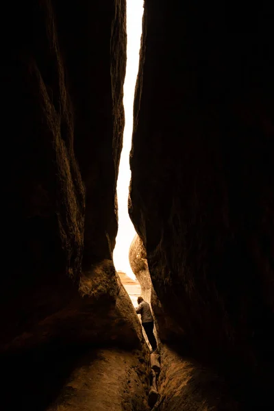 Hiker Carefully Crossing Precarious Passage Way Slot Canyon Cave — стокове фото