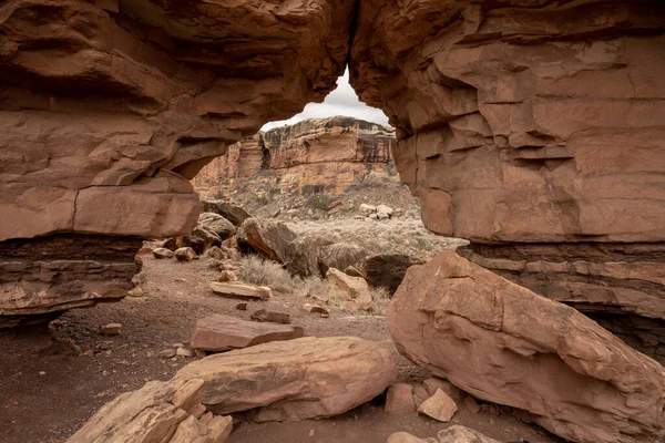 Canyonlands Ulusal Parkı 'ndaki Peekaboo Pınarında Kum Taşı Duvarı' ndan geçen kemer yolu.