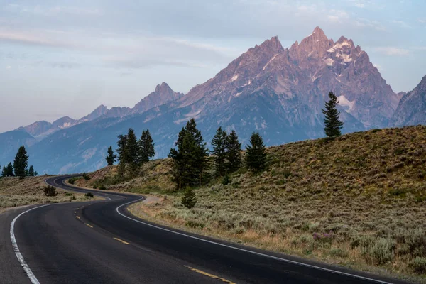 Winding Road Climbs Hillside Front Teton Range — Zdjęcie stockowe