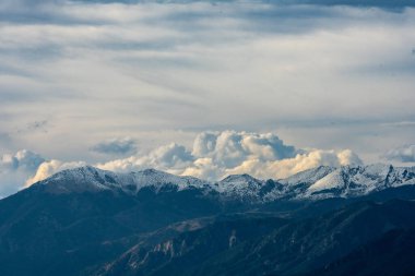 Clouds Brew Over Snow Capped Mountains in Colorado above the Great Sand Dunes National Park