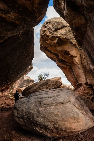 Hiker Passes Large Boulder Rock Pile Cave Canyonlands National Park — Foto de Stock