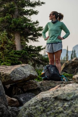 Woman Sets Backpack Down For A Break In Boulder Field in Rocky Mountain National Park