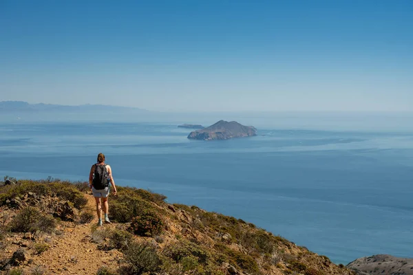 Woman Hikes On Santa Cruz Island With Anacapa In The Distance in Channel Islands National Park