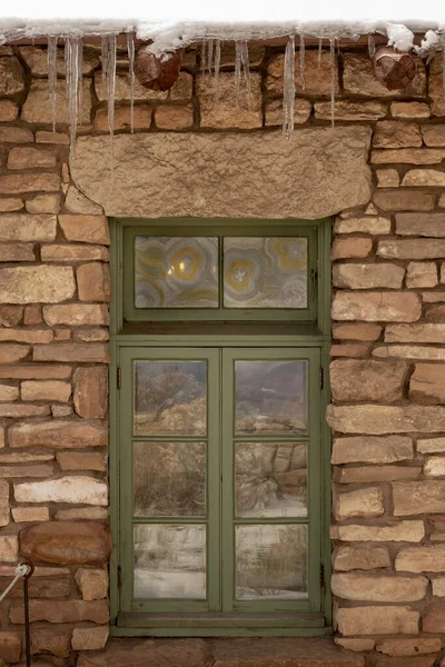 Zielone Okno Dekoracyjnym Szkłem Kamiennej Ścianie Soplami Zimie — Zdjęcie stockowe