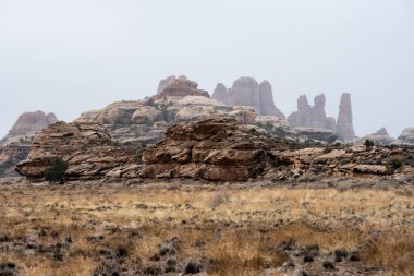 Kaya oluşumlarının katmanları Kanyonlar Ulusal Parkı 'ndaki Bulutların Arasında Kaybolur