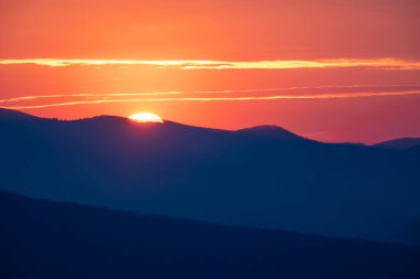 Güneş, Büyük Dumanlı Dağlar Ulusal Parkı 'nın üzerindeki tepeyi kırıyor.