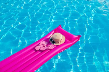 Yaz tatili geçmişi. Şişme şişme yatak, parmak arası terlik ve yüzme havuzunda şapka..