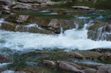 Taşlar ve küçük şelaleli dağ nehri, bulanık arkaplan