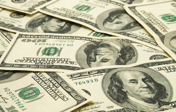 One hundred dollars pile as background.