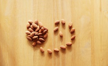 Badem tohumları izole edilmiş arkaplan. Badem ahşap masada.