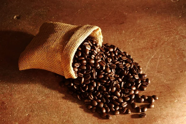 Röstkaffeebohnen Die Aus Braunem Sack Auf Braunem Hintergrund Verschüttet Werden — Stockfoto