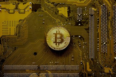 Golden bitcoin on computer motherboard, Bitcoin mining concept