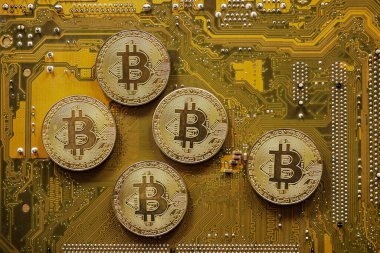Golden bitcoin on computer motherboard, Bitcoin mining concept