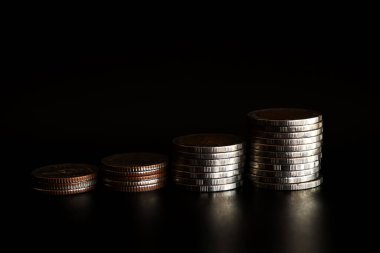 Siyah arkaplanda para yığını, para biriktirme kavramı