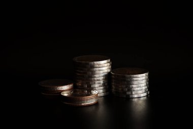 Siyah arkaplanda para yığını, para biriktirme kavramı