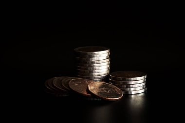 Siyah arkaplanda para yığını, para biriktirme kavramı