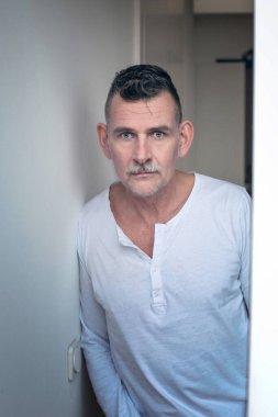 50 'li yaşlarda kameraya bakan yakışıklı bir adamın portresi.