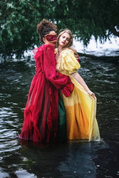 Two Women Historic Gowns Standing Water Hugging — Stockfoto