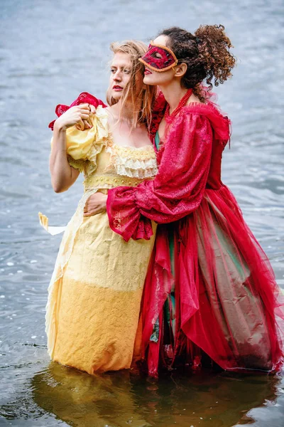 Two Women Historic Gowns Standing Water Hugging — Stockfoto