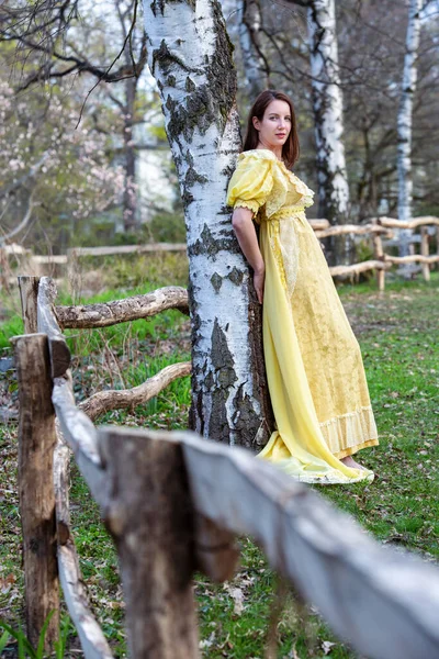 Portret Młodej Kobiety Zewnątrz Historycznej Żółtej Sukience Opartej Drzewie — Zdjęcie stockowe