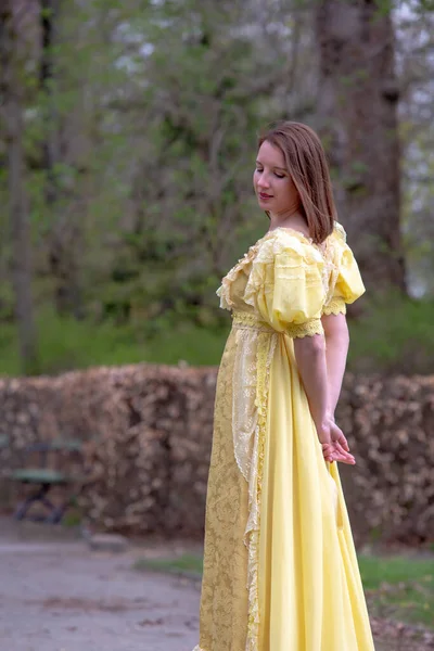穿着历史黄色连衣裙的年轻女子的画像 — 图库照片