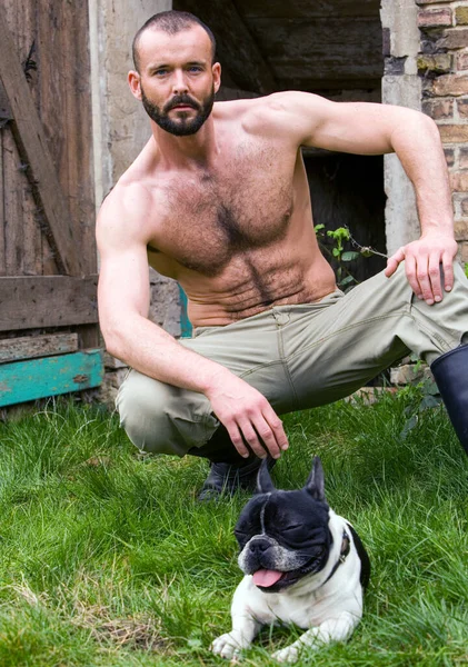 可愛い犬と一緒に納屋でセクシーな白人男性の肖像画 — ストック写真