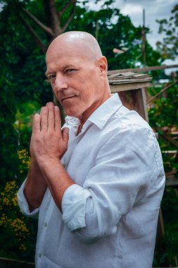 50 'li yaşlarda yakışıklı bir adamın portresi. Doğada ayakta duruyor.