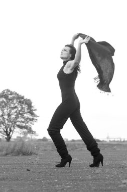 Rüzgarlı bir günde dışarıda yürüyen bir kadın. siyah beyaz fotoğraf.